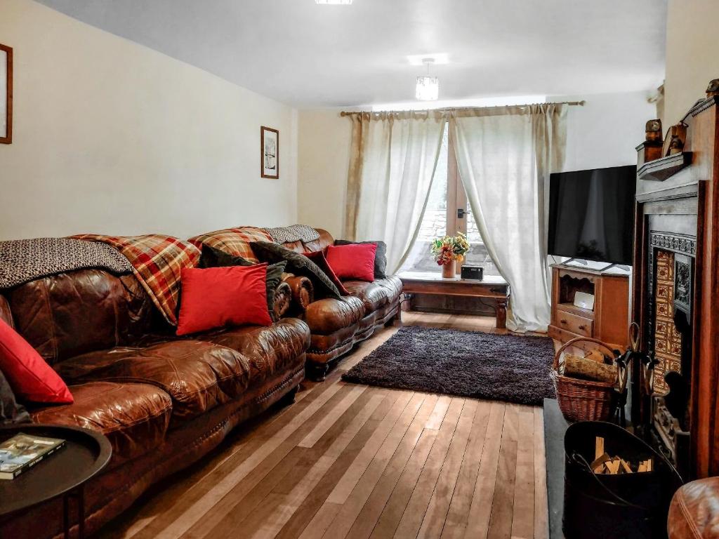 CliburnGrange Court的客厅配有棕色真皮沙发和电视