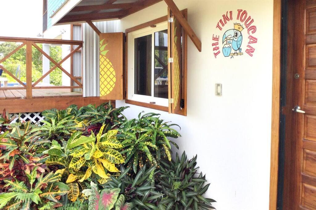 珀拉什奇亚The Tiki Toucan Tropical Suite + Private Pool的一侧有窗户和植物的建筑