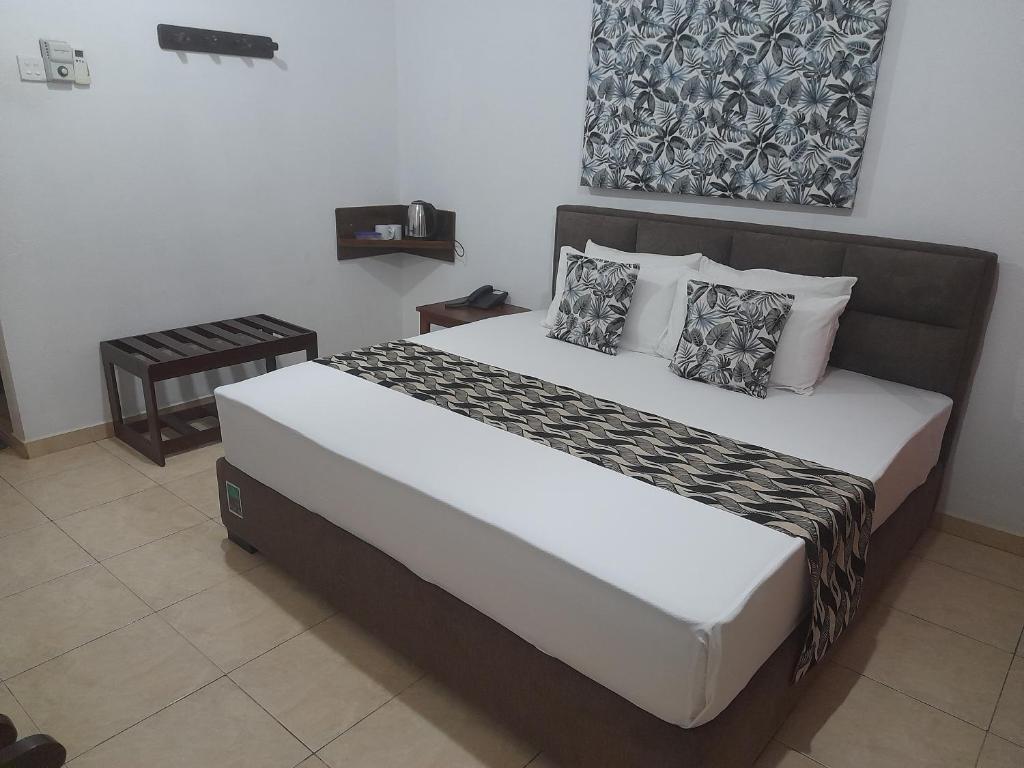 瓦都瓦Larn's Villa Hotel & Apartment的一间卧室配有一张带枕头的大床