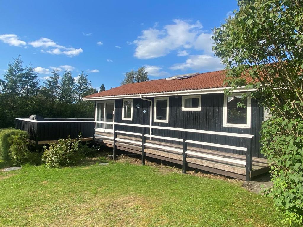 BønnerupSkønt sommerhus tæt på skov, strand og hyggeligt havnemiljø的一座带围栏的黑白房子