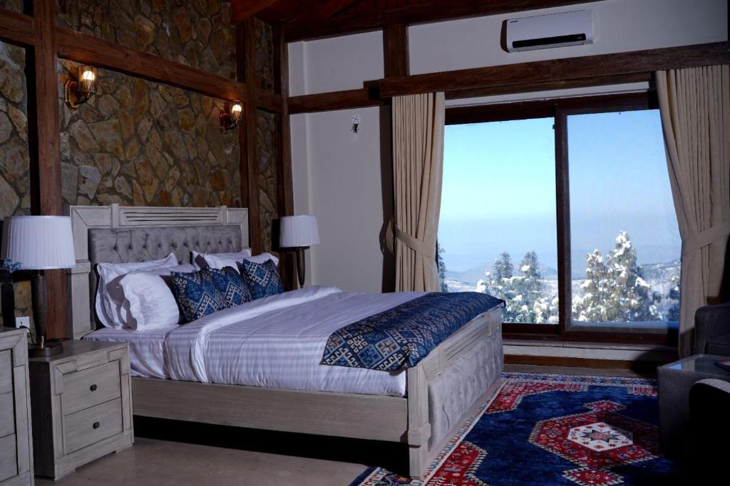 Chhāngla GaliCedar Lodges Resort and Residences Galiyat的一间卧室设有一张床和一个大窗户