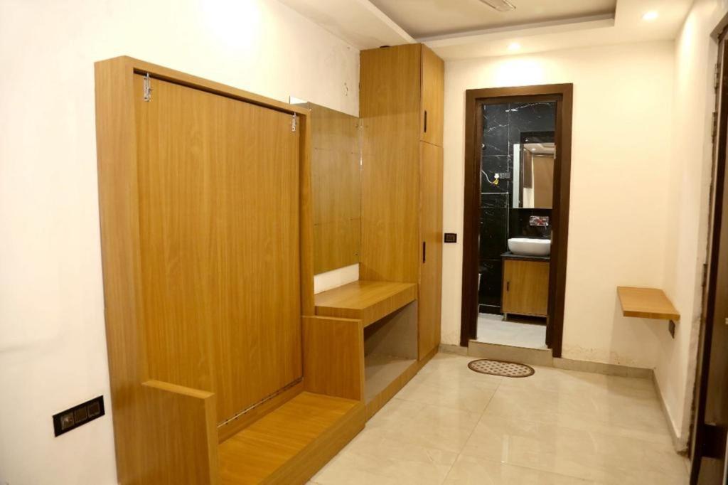 新德里Bunk Hostel Delhi Best Backpacking Accommodation的一间带木门和水槽的浴室