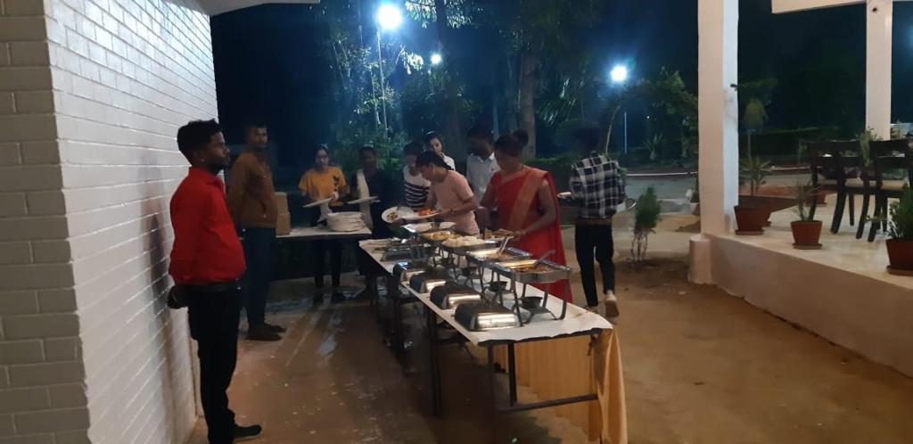 克久拉霍The Baagh Jungle Resort的一群人站在桌子旁吃着食物