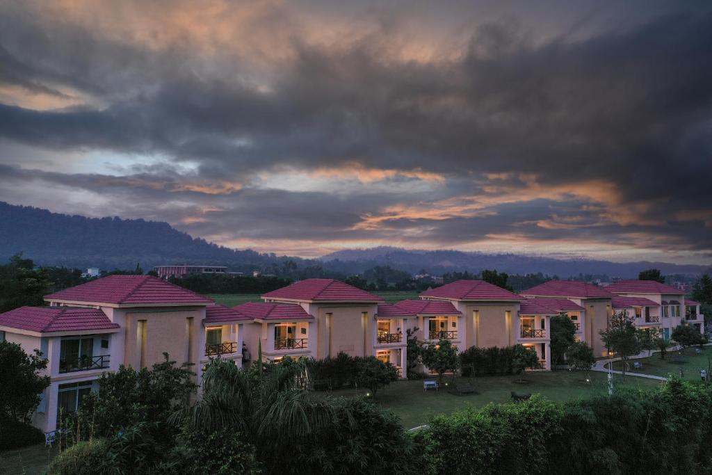 兰纳加Resort De Coracao - Corbett , Uttarakhand的一片阴云天下一排有粉红色屋顶的房屋