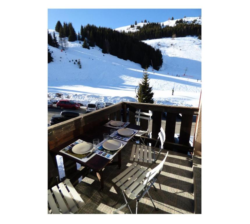奥瑞斯Appartement 6 pers. pied des pistes 69584的一个带滑雪坡的阳台的桌椅