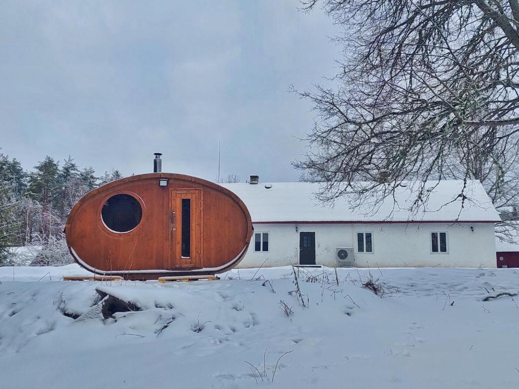 LiguriPaganamaa puhkemaja ja peosaal的雪中一座大型的木制椭圆形建筑