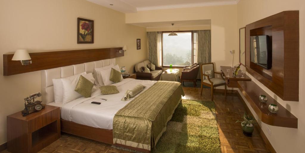 乌提宝石公园乌蒂酒店的酒店客房设有床和客厅。
