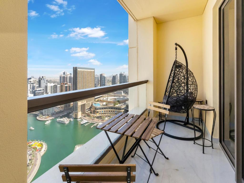 迪拜FAM Living - Stunning 2 Bedroom Home In JBR的阳台配有长凳和秋千。