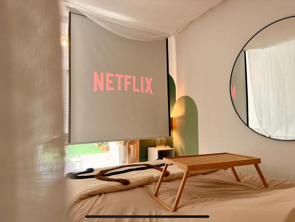 阿格德角Super Mini Loft avec Cinéma et Jardin - Cap d'Agde的床上墙上的标牌,带桌子