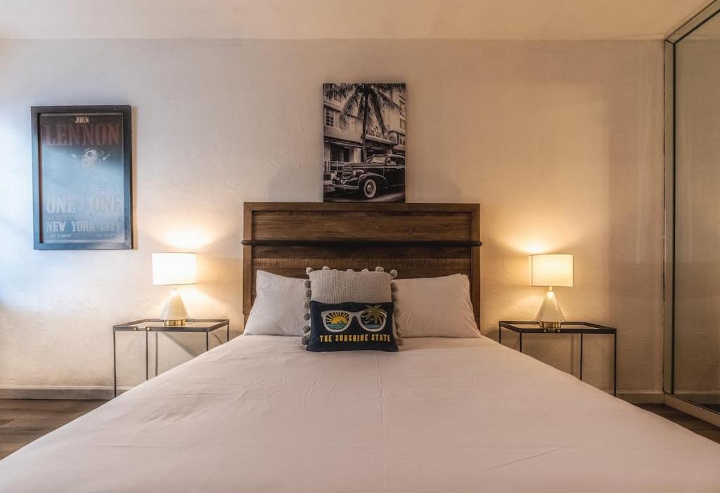 迈阿密海滩Travelers Hideout Located 1 block from the beach的一间卧室配有一张带两盏灯的大型白色床。