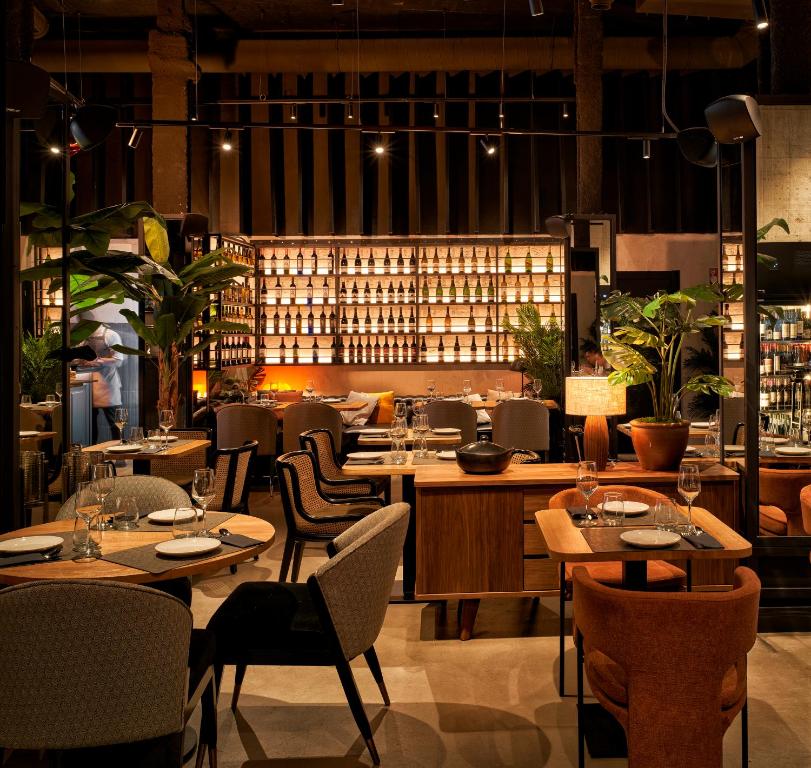 毕尔巴鄂Bilder Boutique Hotel的一间带桌椅和葡萄酒瓶的餐厅
