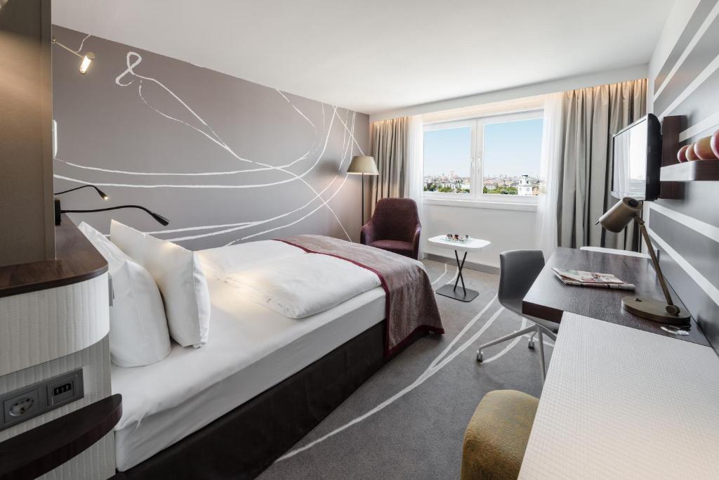 慕尼黑慕尼黑市中心假日酒店的配有一张床和一张书桌的酒店客房