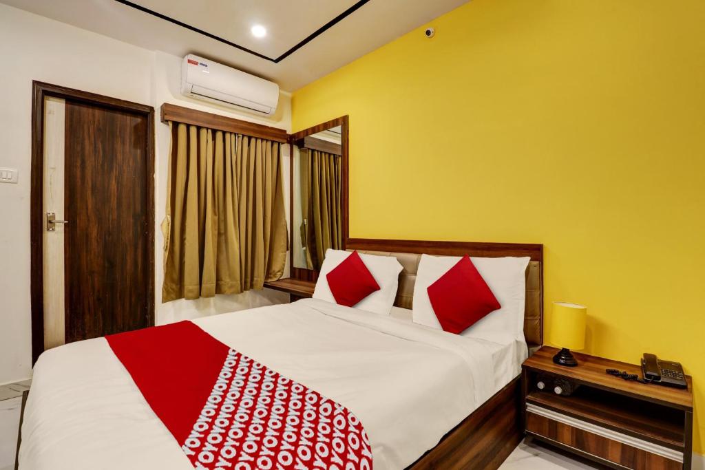 班加罗尔OYO Hotel Golden Residency的一间卧室配有红色和白色枕头的床