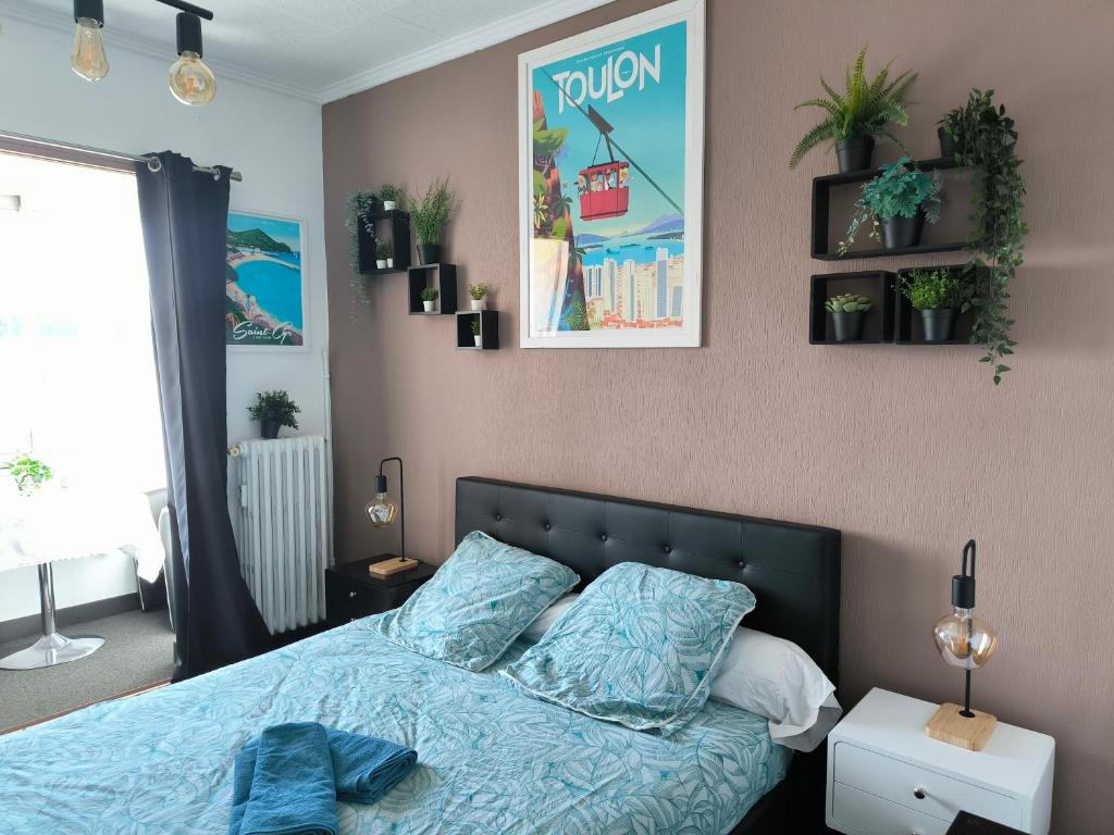 土伦Les Résidences du Mourillon的一间卧室配有一张带蓝色床单和植物的床。