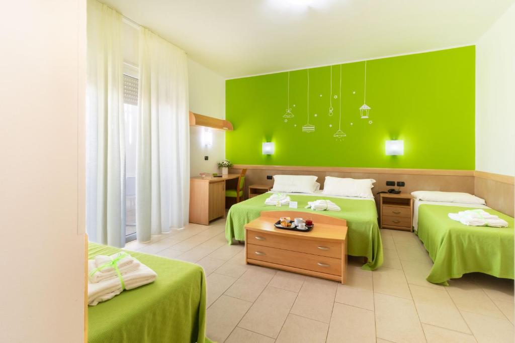 丽都玛里尼Marini Hotel B&B的绿色客房 - 带两张带绿色墙壁的床