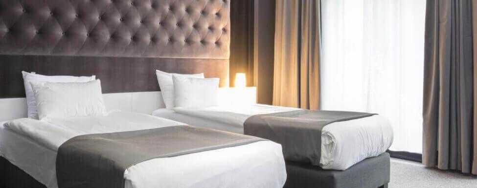 亭可马里DOCKYARD HOTEL的酒店客房设有两张床和大窗户。