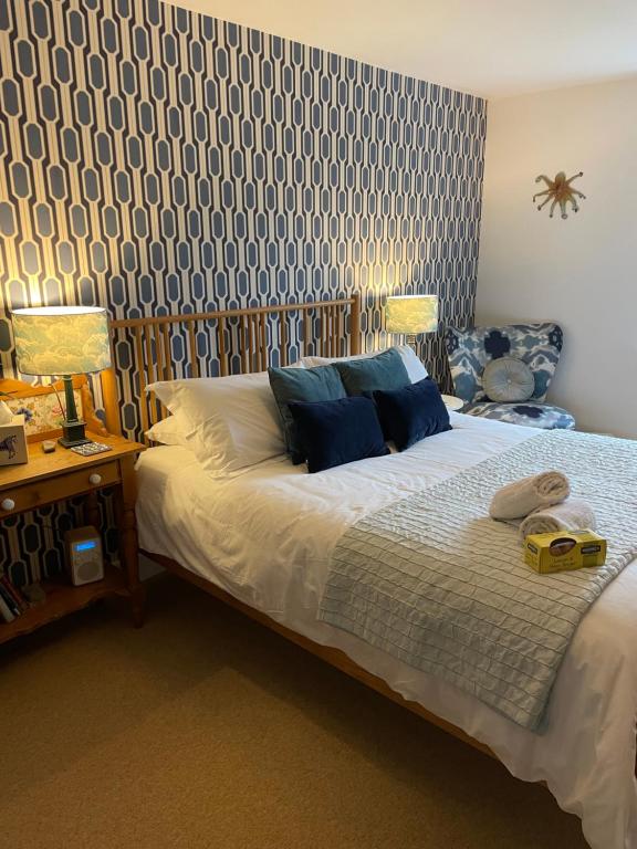 莱姆里吉斯No 12的一间卧室配有蓝色和白色壁纸的床