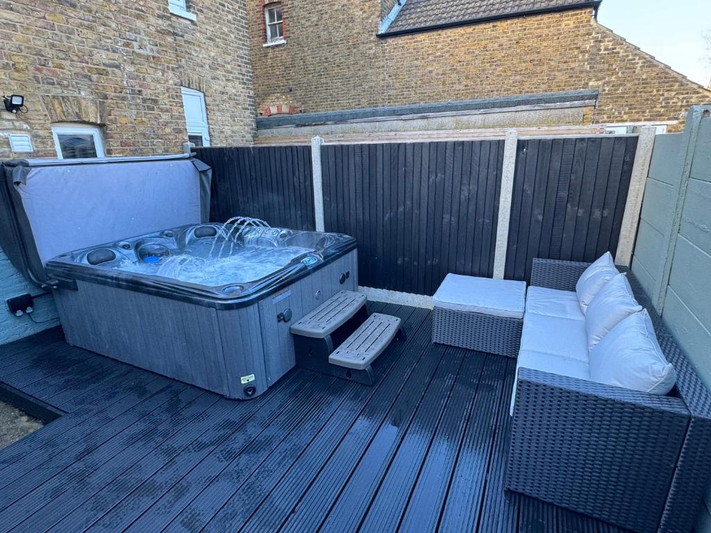 KentBroadway Terrace with Hot tub的甲板上的热水浴池,配有长凳