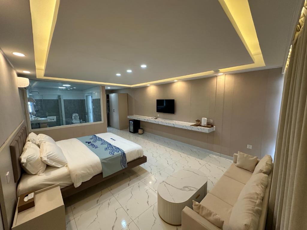 马比尼Luckytito Anilao Resort的一间大卧室,配有一张床和一张沙发