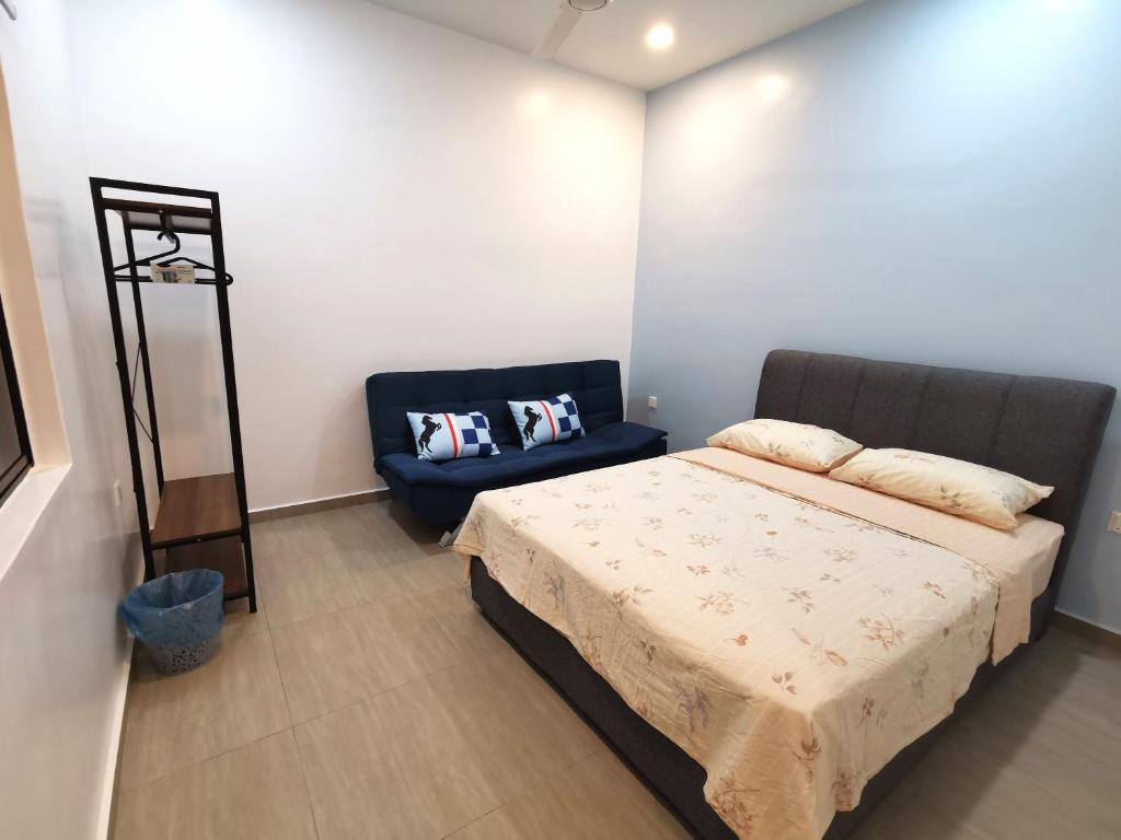 新古毛Amuse Homestay at Kuala Kubu Bharu的一间卧室配有一张床和一张蓝色椅子