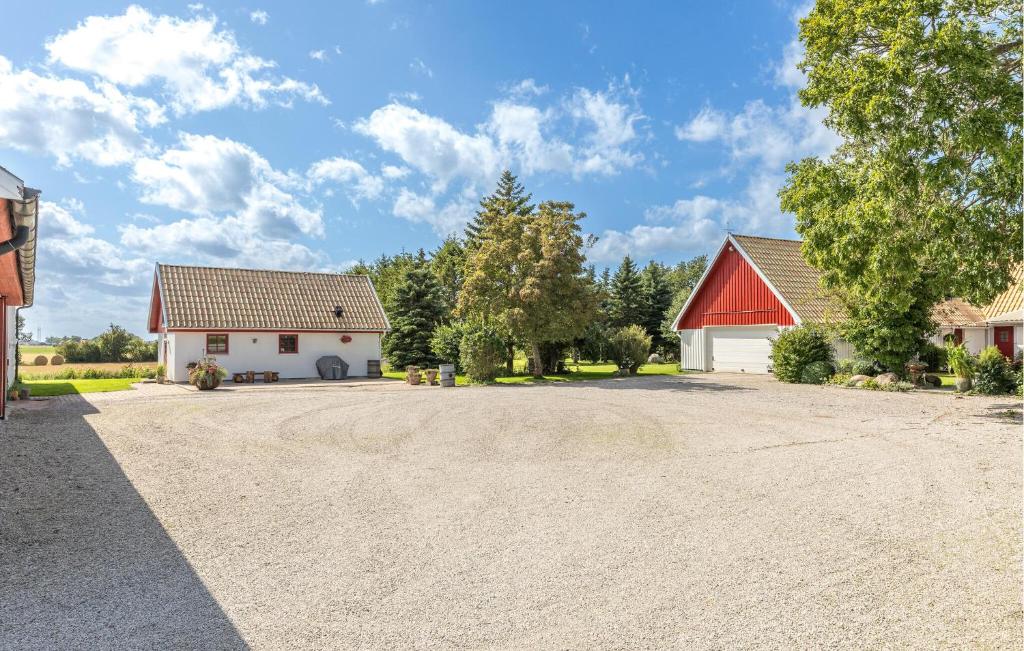 隆德Cozy Home In Lund With Kitchen的车道,两栋建筑和红色屋顶