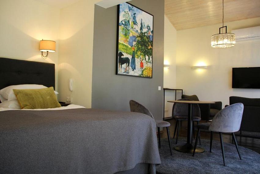 特拉凯Margis Hotel & SPA的酒店客房带一张床、一张桌子和椅子