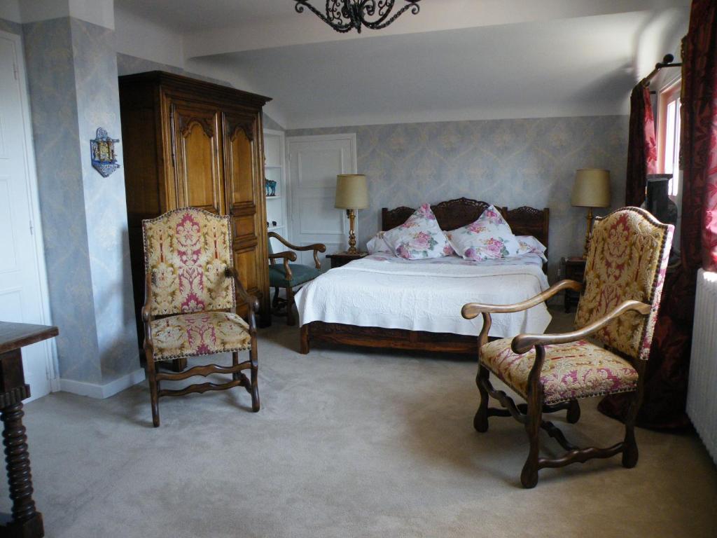 西布勒Villa Erresiñolettean的一间卧室配有一张床和两把椅子
