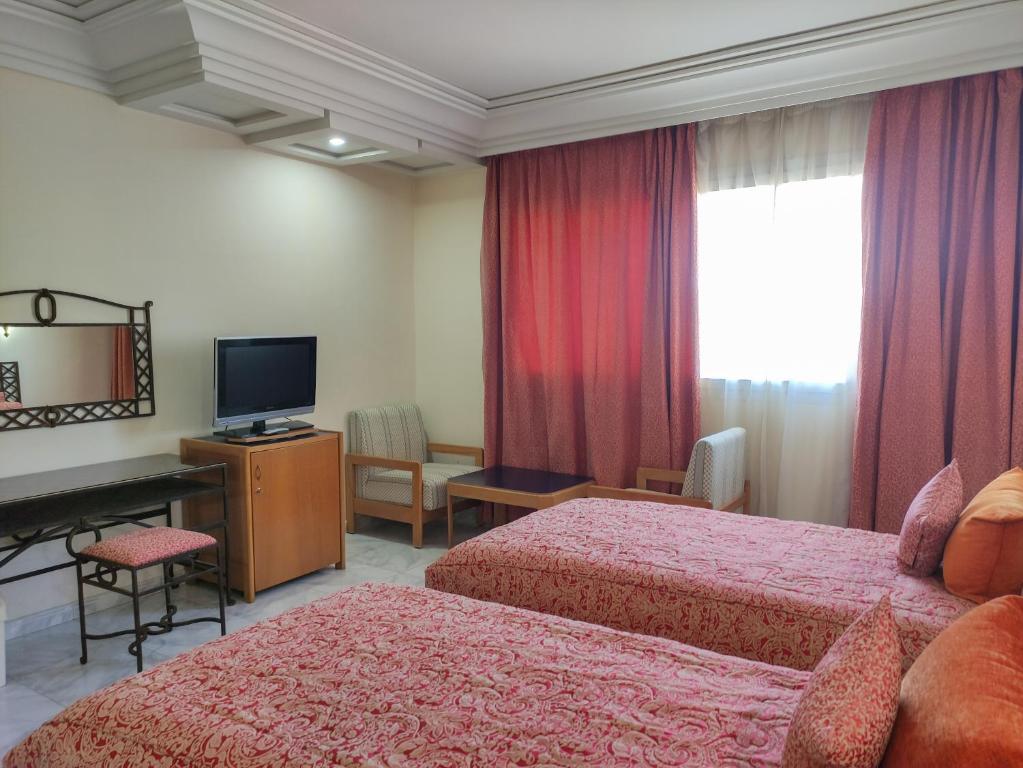 提兹尼特Hotel Idou Tiznit的酒店客房设有两张床和电视。