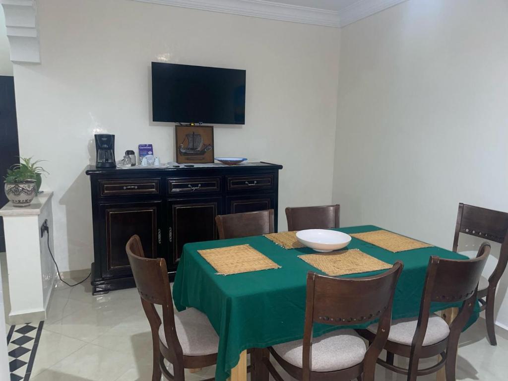 沃利迪耶Dar Malaika的一间带绿桌和电视的用餐室