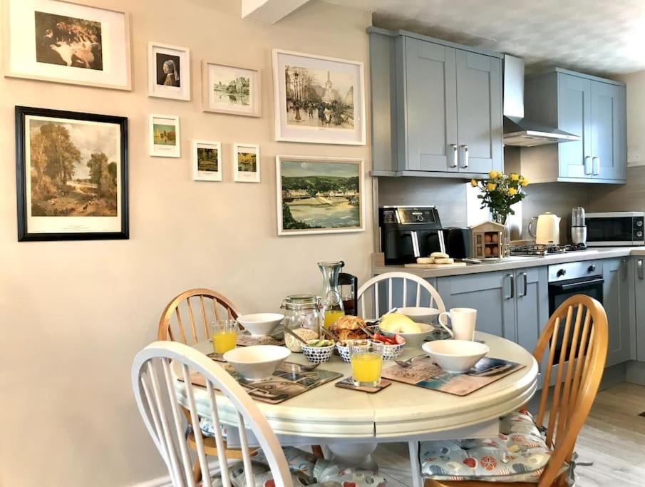 彭布罗克郡Charming Coastal Getaway - Pembroke的厨房配有桌椅和食物