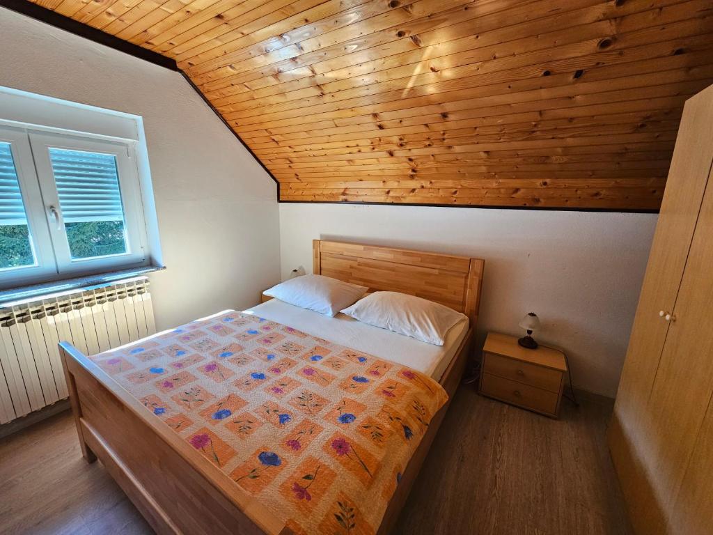 斯莫利亚纳茨米里亚娜宾馆的一间卧室设有一张床和木制天花板