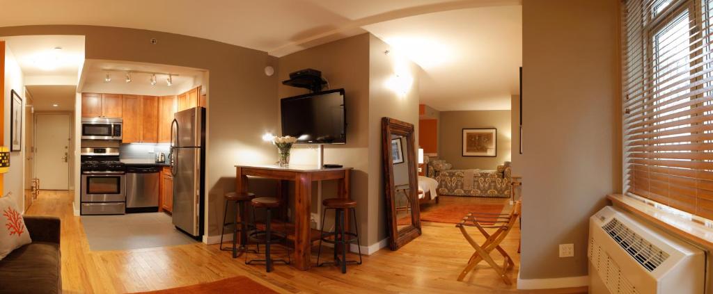 纽约纽约保护区度假公寓式酒店的一间带厨房的客厅和一间带电视的客厅。