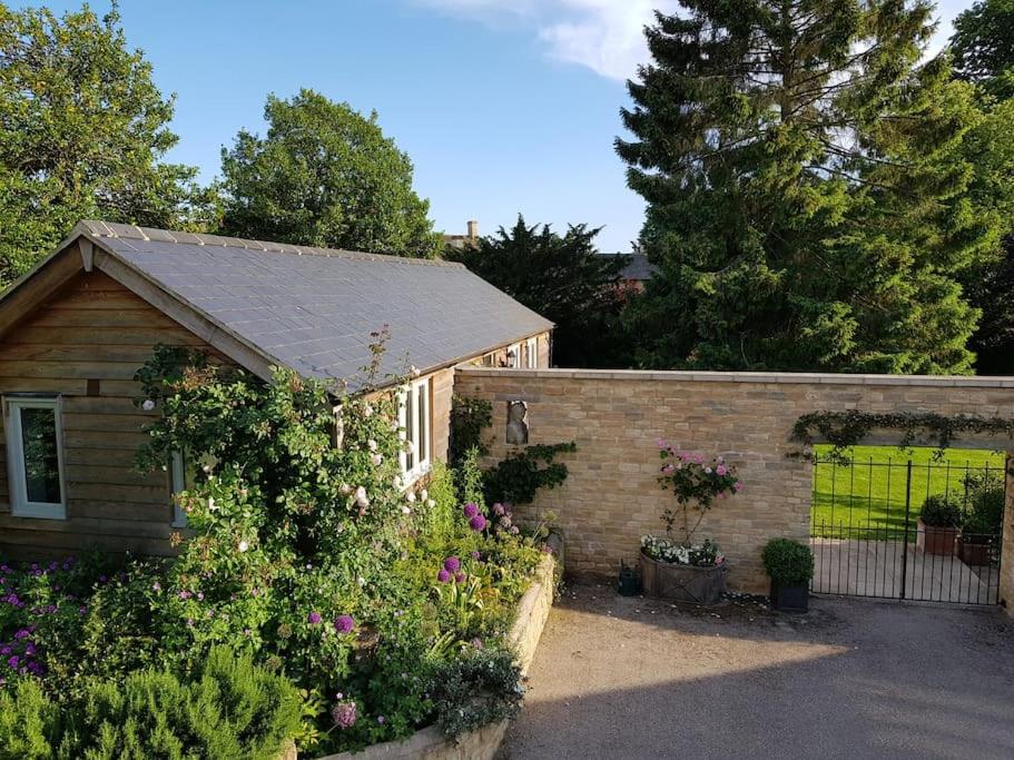 查尔伯里Charming Cottage surrounded by Idyllic garden in peaceful location in central Charlbury的一座带鲜花和围栏的花园的房子