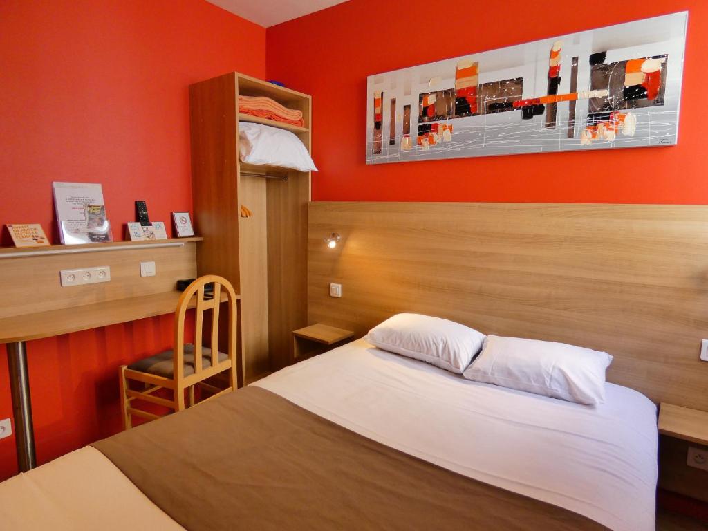 科涅克Logis Hôtel La Résidence的一间卧室配有一张橙色墙壁的床