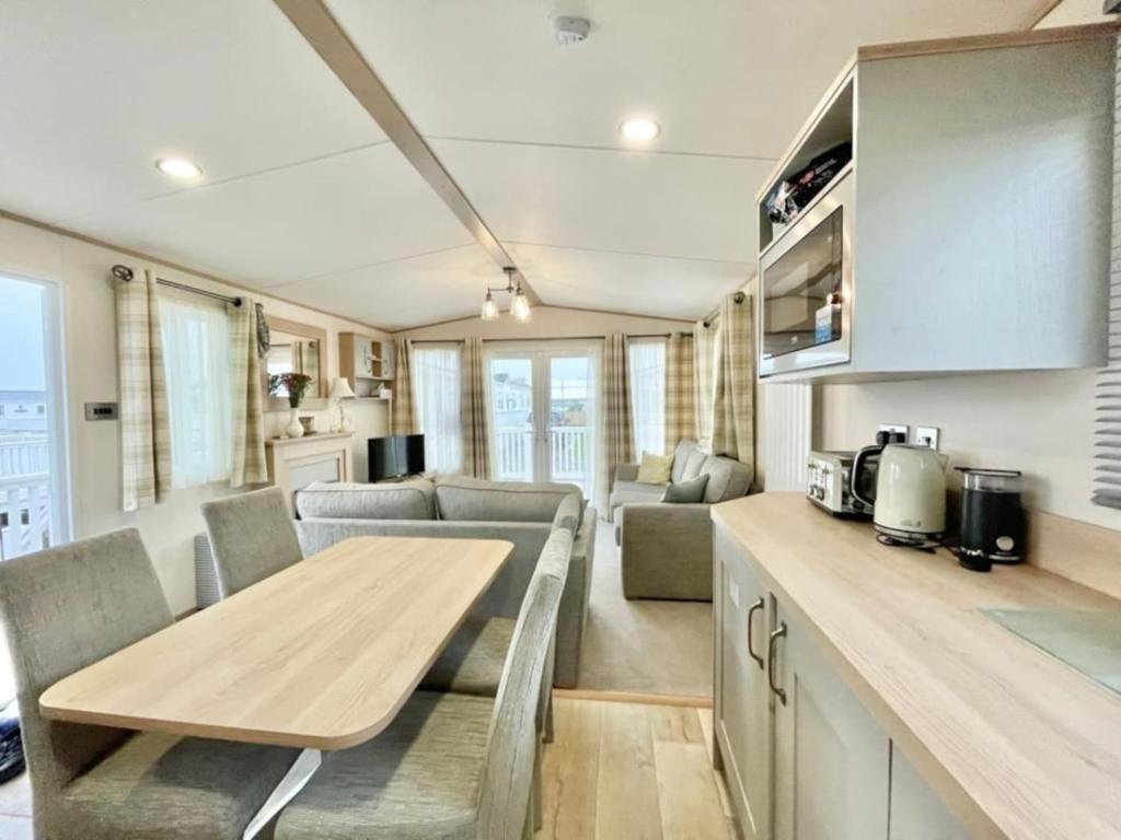 坎伯利BW8 - 3B - ABI Windermere的一间厨房和客厅,客厅配有大篷车内的桌子