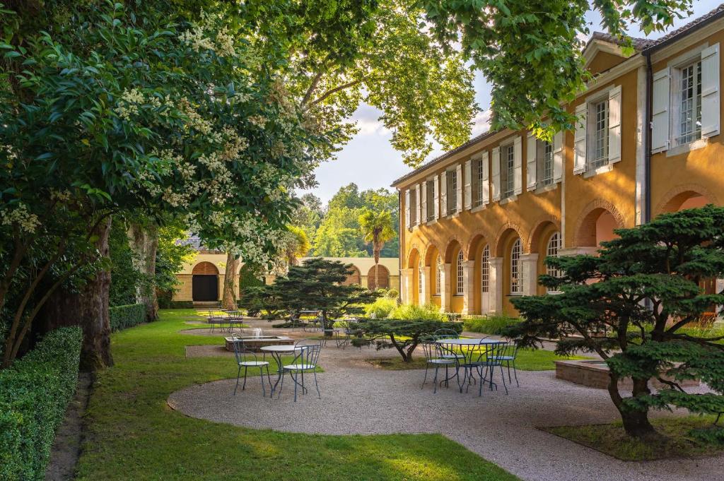 巴布通莱班La Bastide en Gascogne的一个带桌椅的庭院和一座建筑