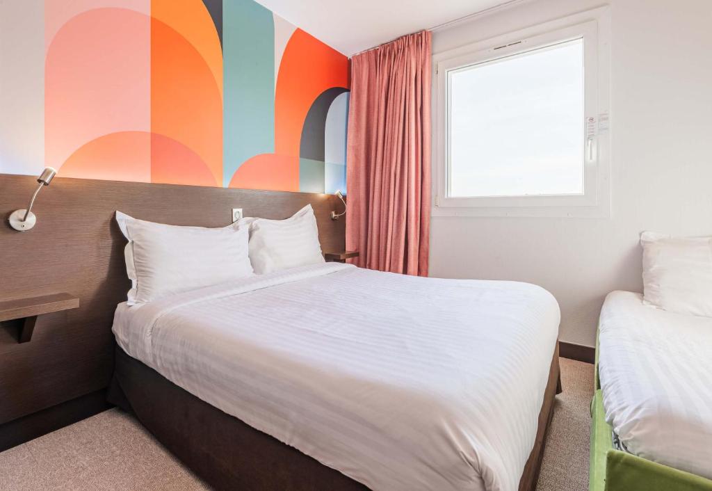 科尔马B&B HOTEL Colmar Liberté 4 étoiles的一间卧室设有一张床和色彩缤纷的墙壁