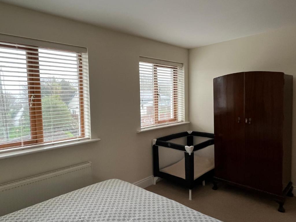 阿德莫尔Ardmore Village Family Home的一间卧室配有一张床、一个梳妆台和两个窗户。