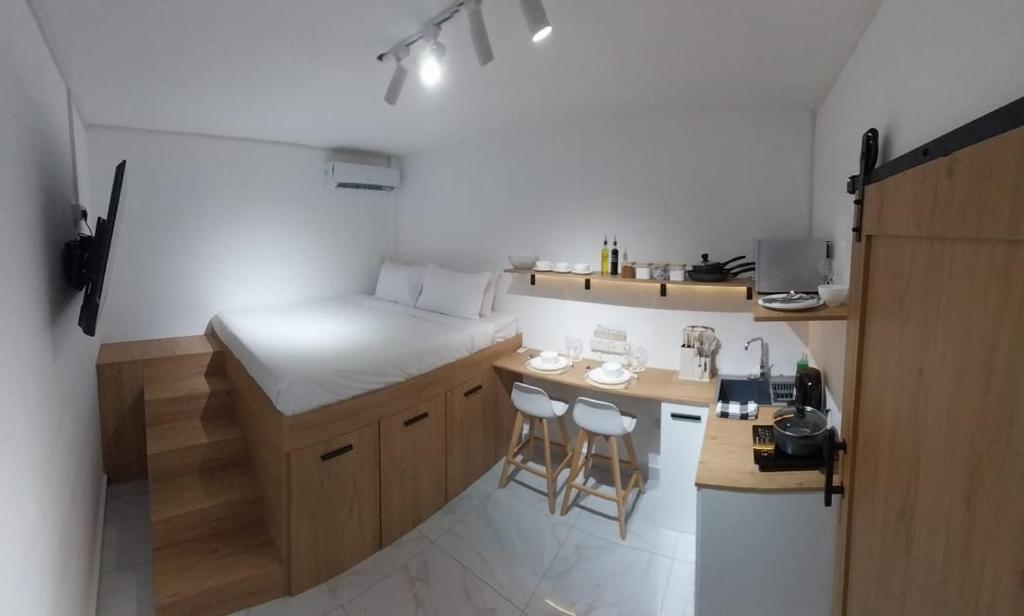 格兰贝伊Cosy studio with all amenities的一间带床和凳子台的小厨房