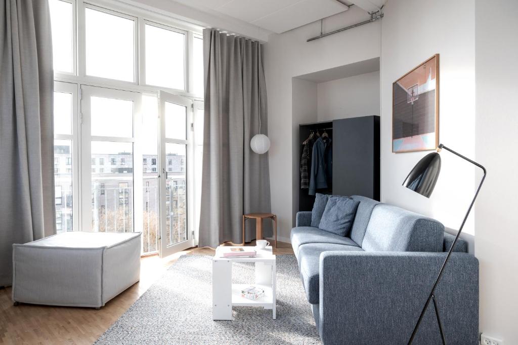 哥本哈根Beach Trail apartments by Daniel&Jacob's的客厅设有蓝色的沙发和大窗户