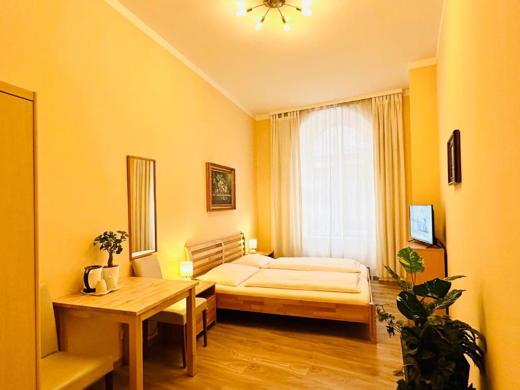 维也纳列支敦士登旅馆的一间卧室配有一张床、一张桌子和一个窗户。
