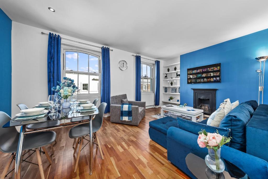 伦敦Blue Themed Luxury 1 Bedroom Balcony Flat, With Double Sofa Bed and Fast Wifi! Accommodates up to 6 Guests! Hyde Park!的客厅拥有蓝色的墙壁和蓝色的沙发