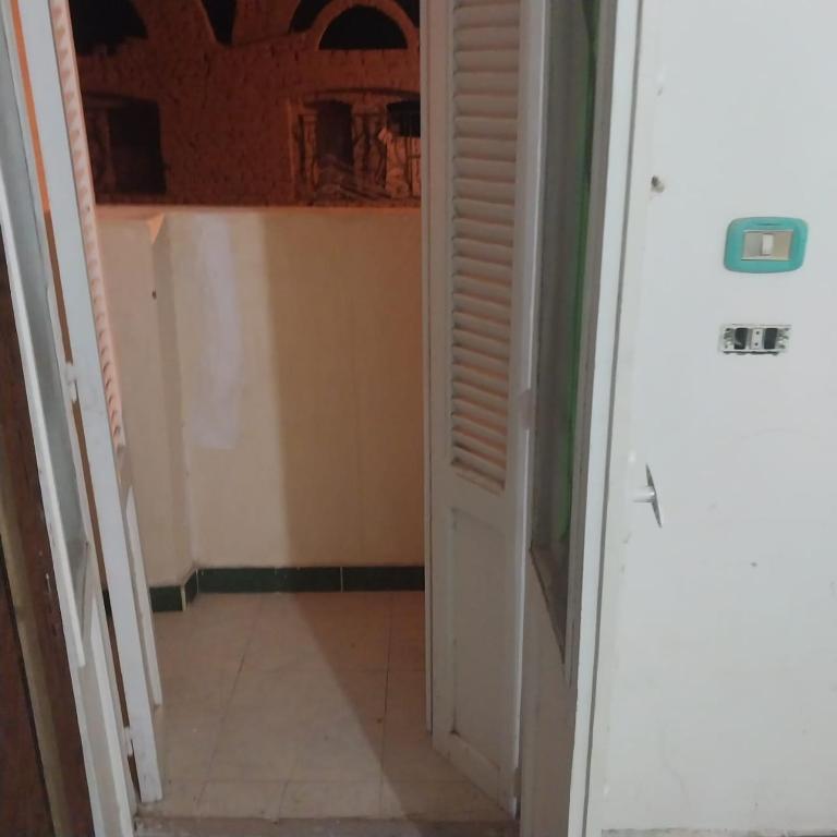 阿布辛贝Adel Hotel的走廊设有白色门,铺有瓷砖地板
