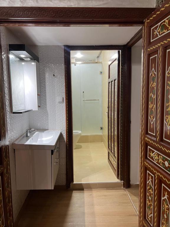 拉巴特Riad el wazania的一间带水槽、镜子和门的浴室