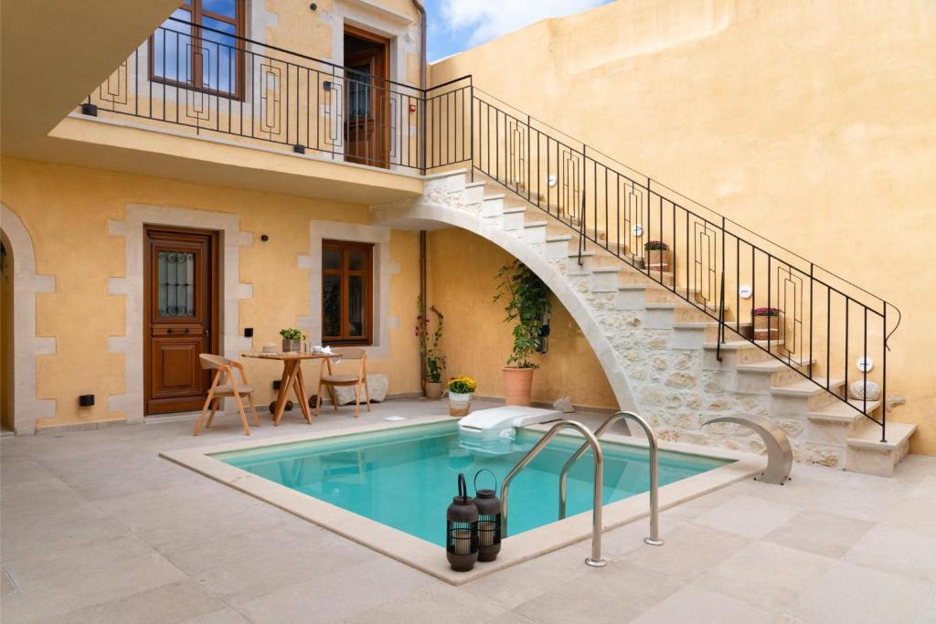 罗希姆诺Mansio Boutique Hotel的庭院内的游泳池,旁边设有楼梯