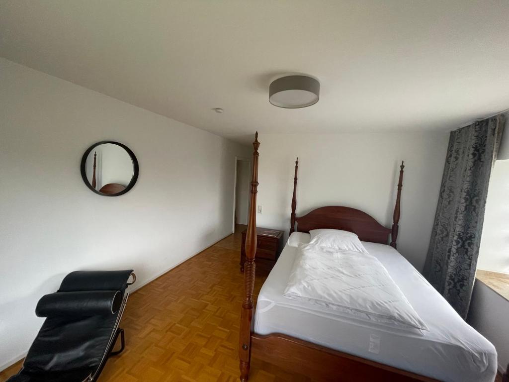 克雷费尔德Ferienwohnung Wohnung Krefeld Forstwald Höltehoffe的一间卧室配有一张床、镜子和椅子