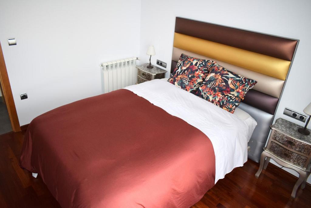 耶克拉Alojamientos Yecla Centro by Casa de la Feria del Mueble Yecla的一间卧室配有一张大床,铺有红白毯子