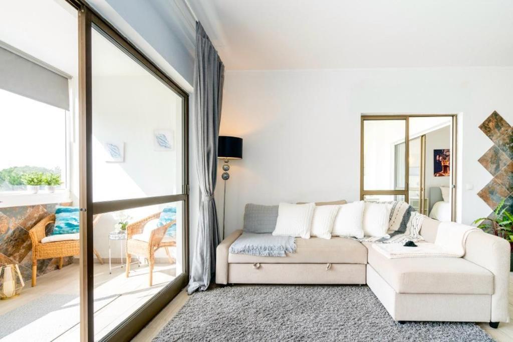奎特里拉Spacious 1 bed in Vilamoura, Fast Wifi & Pool的客厅配有白色沙发和大窗户