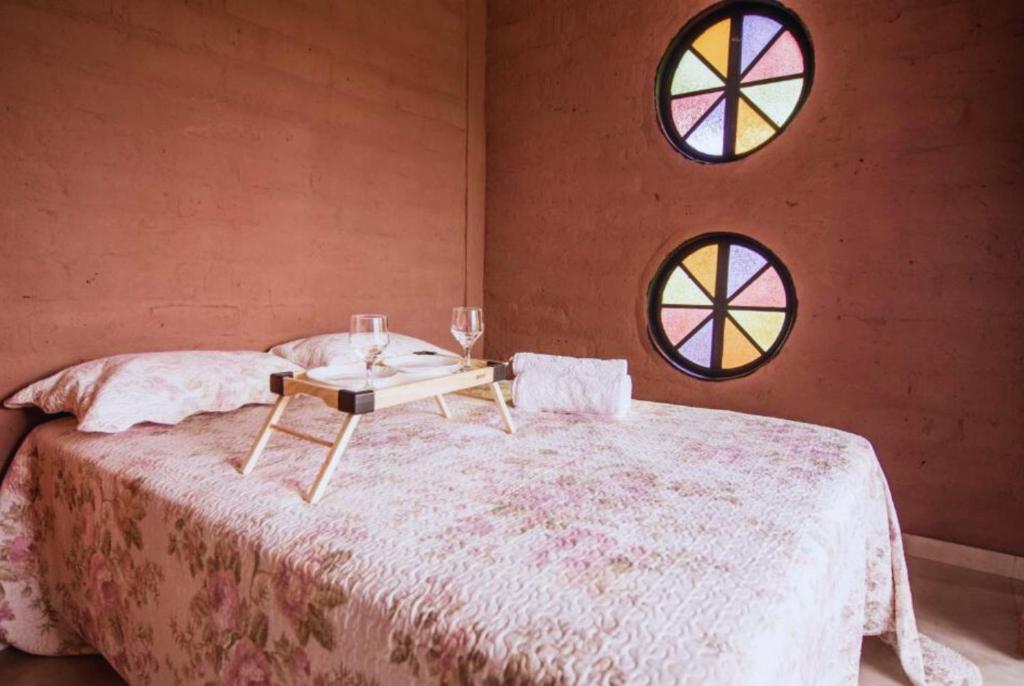 戈亚斯州上帕莱索Daya Ma Hospedagem的一间卧室配有一张桌子和两个窗户。