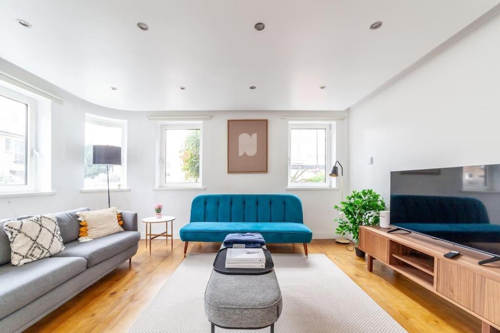 伦敦Stylish 3-bed near Camden Town & King's Cross的客厅配有2张蓝色沙发和电视